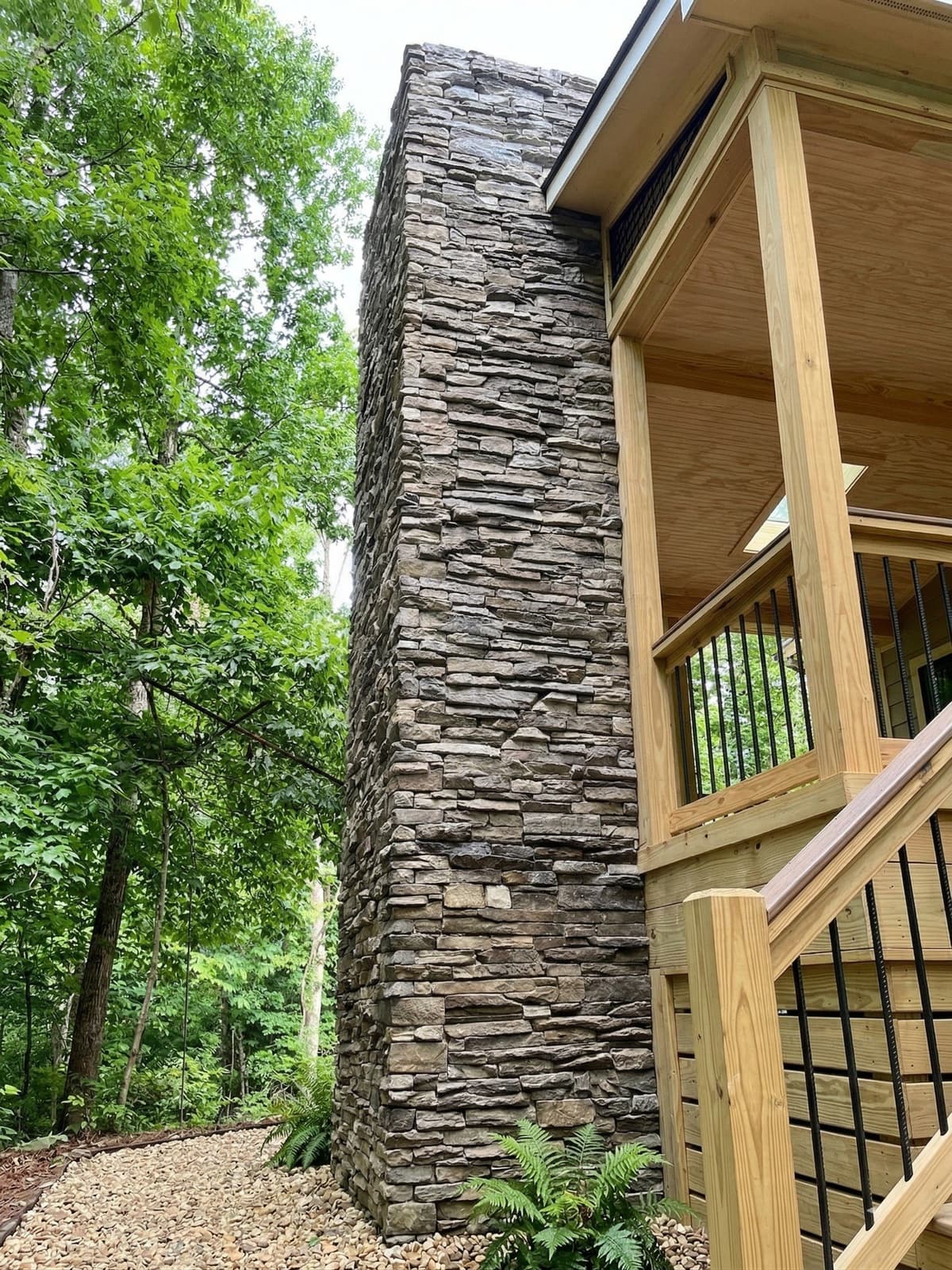 Stone outdoor fireplace with a matching sitting wall on a large acreage lot in Waxhaw, NC